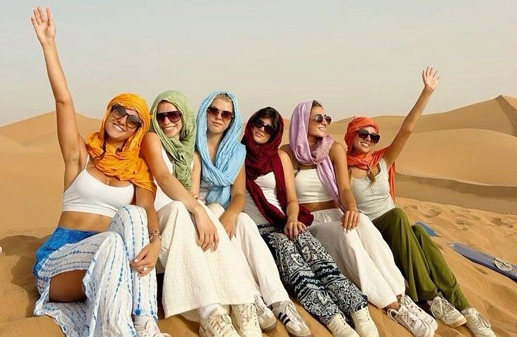 2 Days Tour From Marrakech To Zagora Desert 1 Happy travelers enjoying sunset in Zagora desert during 2 days tour from Marrakech