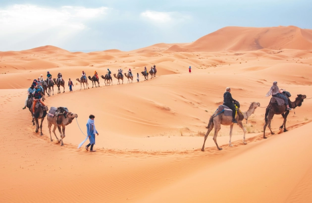 Camel trekking in Erg Chebbi dunes during sunset on a 4 days tour from Marrakech to Merzouga