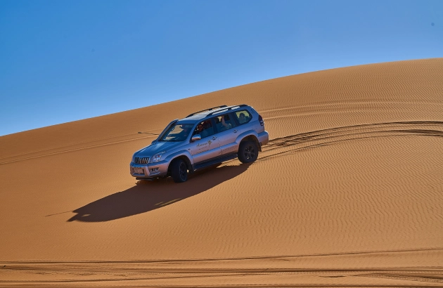 Merzouga 4x4 Desert Tour 1 4x4 vehicle driving through Erg Chebbi sand dunes in Merzouga